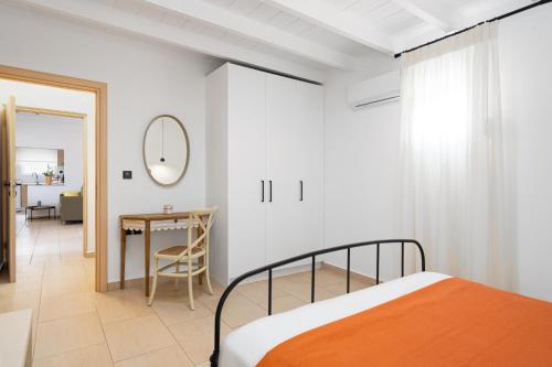 a bedroom with a bed and a table and a mirror at Villa Kalliopi ΙnCreteble Cretan Resindences Collection in Xerokampos