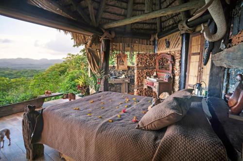 a bed in a room with a view at Casa El Paraiso, Eco Lodge in Santa Bárbara de Samaná