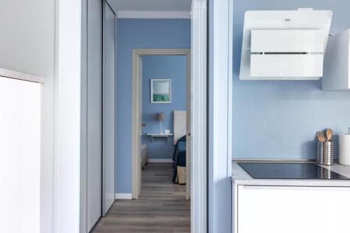 a kitchen with blue walls and a hallway at Apartments Peninsula in Sirmione