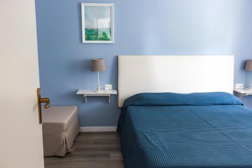 a blue bedroom with a bed and a table at Apartments Peninsula in Sirmione