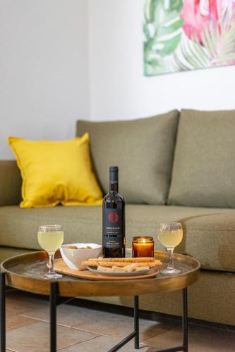 a bottle of wine and two glasses on a coffee table at Villa Kalliopi ΙnCreteble Cretan Resindences Collection in Xerokampos