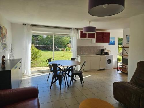 a kitchen and living room with a table and chairs at MAISON avec 1 CHAMBRE dans QUARTIER RESIDENTIEL VERDOYANT CALME in Vendays-Montalivet