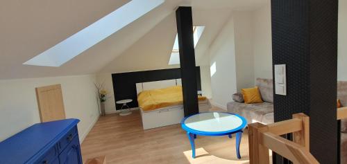 um quarto no sótão com uma cama e um banco azul em Apartamenty w Sercu Sosnówki em Sosnówka