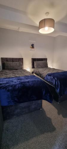 a bedroom with two beds with a blue blanket on them at The Old Workshop Oxford Countryside Apartment - Wifi - Free Parking in Oxford