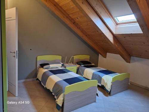 2 camas en una habitación con ático en Casa Matilde, en Leinì