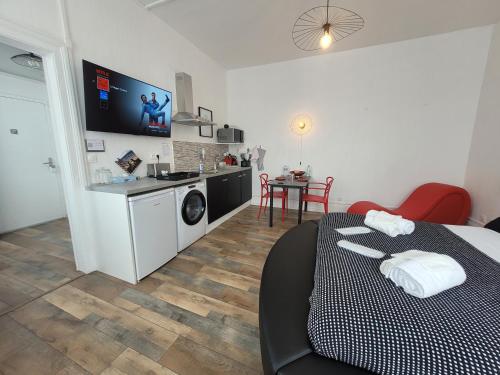 um quarto com uma cama e uma cozinha com uma mesa em L'Hyper Centre - Netflix & Wifi - Lit Haut de Gamme & Sofa Tantra - check-in 24H24 - GoodMarning em Châlons-en-Champagne