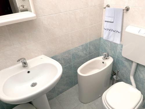 uma casa de banho com um lavatório e um WC em Hotel Villa Augusta em Grado