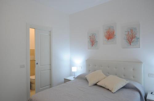 a bedroom with a bed and two paintings on the wall at 2 Camere 50m dal Mare e Parcheggio Privato in Marina di Pietrasanta