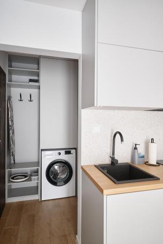 a kitchen with a sink and a washing machine at Moon Apartment in Rzeszów