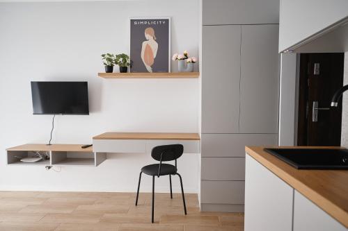 a kitchen with a desk and a chair in a room at Moon Apartment in Rzeszów
