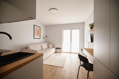 a white living room with a couch and a table at Moon Apartment in Rzeszów