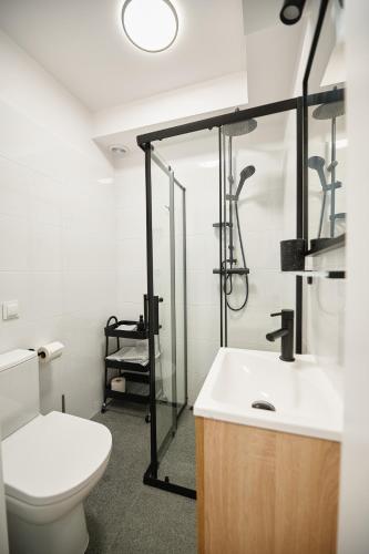 a bathroom with a toilet and a shower and a sink at Moon Apartment in Rzeszów