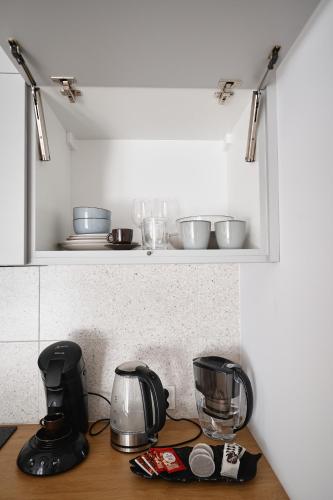a kitchen counter with some appliances on a shelf at Moon Apartment in Rzeszów