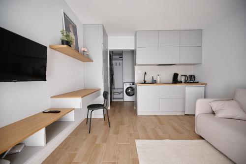 a living room with a couch and a kitchen at Moon Apartment in Rzeszów