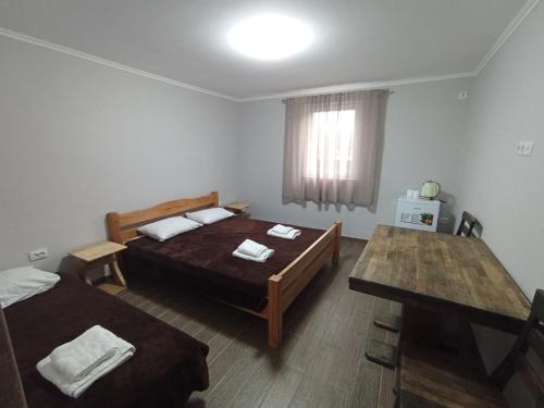 een slaapkamer met 2 bedden en een tafel. bij Family House in Makarovka
