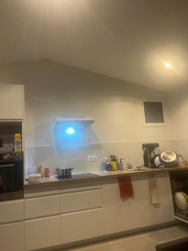 une cuisine avec une lumière bleue sur le comptoir dans l'établissement Appartement BDX, à Bordeaux