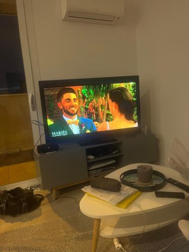 un salon avec une télévision et une table basse dans l'établissement Appartement BDX, à Bordeaux