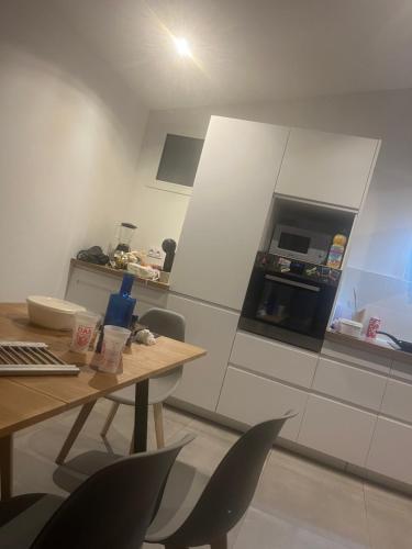 - une cuisine avec une table, des chaises et un four dans l'établissement Appartement BDX, à Bordeaux