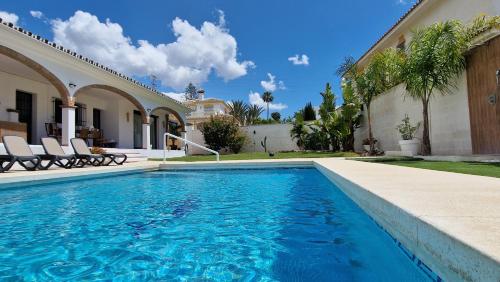 a swimming pool in front of a house at Villa Las Niñas Costa del Sol in Mijas