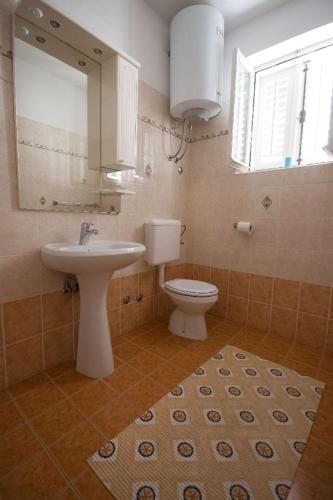a bathroom with a toilet and a sink and a mirror at Sunny Adriatic apartments Valentin in Vrsar