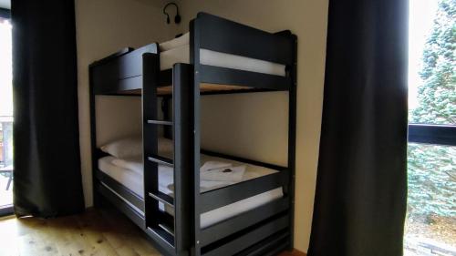 a bunk bed with four bunk beds in a room at Moderní rodinný 3KK apartmán D8 v centru Harrachova s výhledem na skokanské můstky - by Relax Harrachov in Harrachov