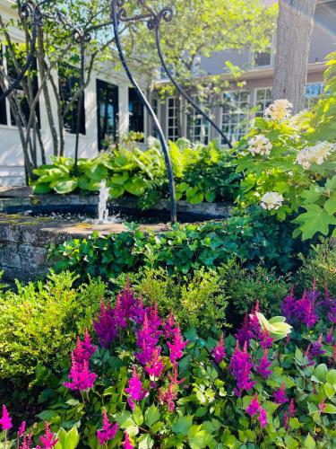 a garden with pink flowers and a fountain at Inn of Chagrin in Chagrin Falls