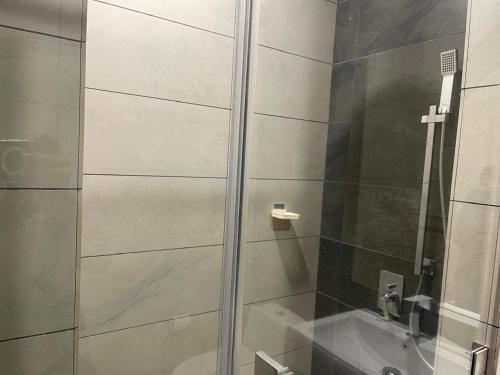 a shower with a glass door next to a sink at Opus Residence Kuala Lumpur by KL Suite in Kuala Lumpur