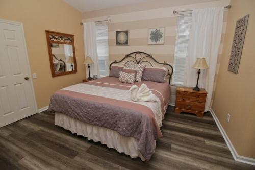 a bedroom with a large bed and a mirror at Luxury Villa Private Pool And Great Game Room in Kissimmee