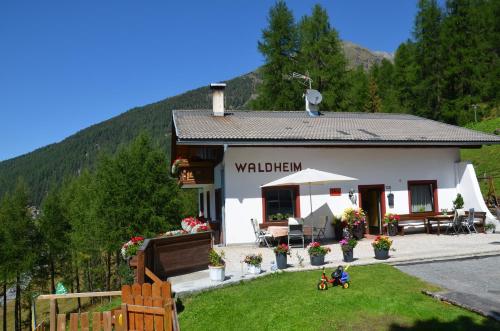 ein kleines weißes Gebäude mit einem Schild, das Wolf enstein liest in der Unterkunft Waldheim in Sulden