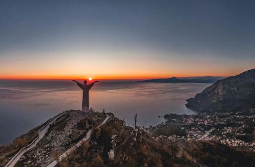 a christ the redeemer on top of a mountain at sunset at San Raffaele Hotel Restaurant & Resort in Castelluccio Superiore