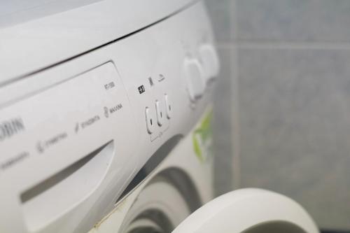 a close up of a washing machine in a bathroom at Pink Sand Sea Apartment in Adelianos Kampos