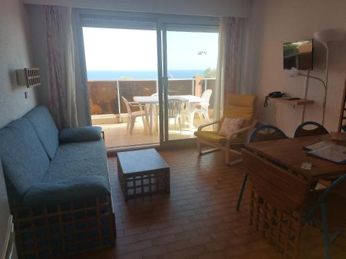 uma sala de estar com um sofá, uma mesa e uma varanda em Dernier étage vue mer exceptionnelle em Roquebrune-Cap-Martin