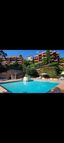 une grande piscine bleue devant un immeuble dans l'établissement Dernier étage vue mer exceptionnelle, à Roquebrune-Cap-Martin