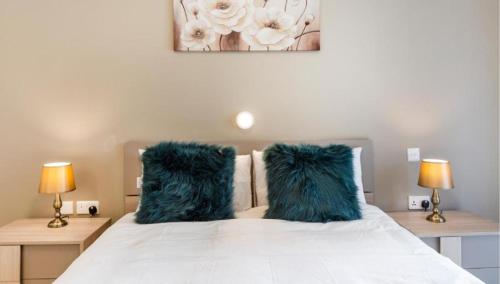 a bedroom with a bed with two blue pillows at Emerald Suite in St Paul's Bay