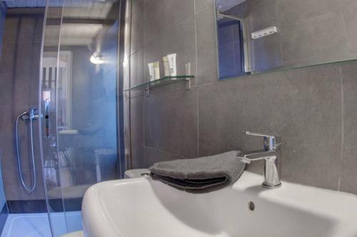 uma casa de banho com um lavatório e um chuveiro em Grace's elegant suite em Corfu Town