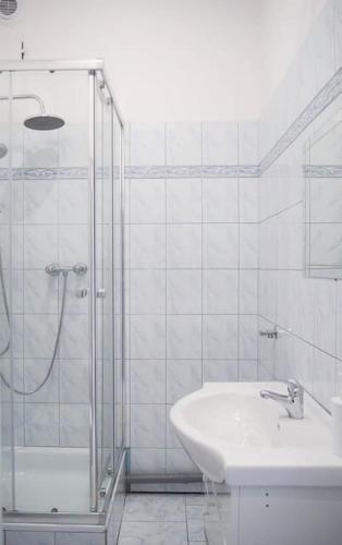 uma casa de banho branca com um chuveiro e um lavatório. em Old Town em Cracóvia