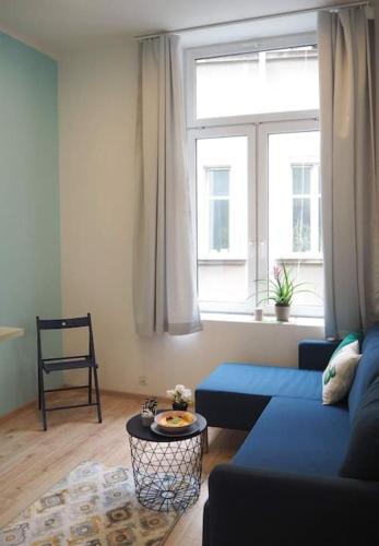 uma sala de estar com um sofá azul e uma janela em Old Town em Cracóvia
