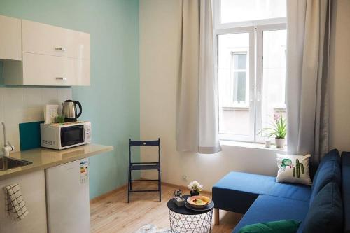 a living room with a blue couch and a kitchen at Old Town in Krakow