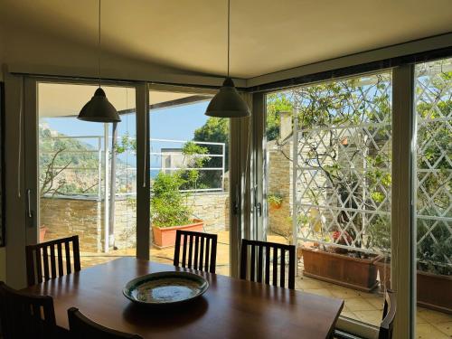 a dining room with a table and a large window at Villa De Simone in Positano
