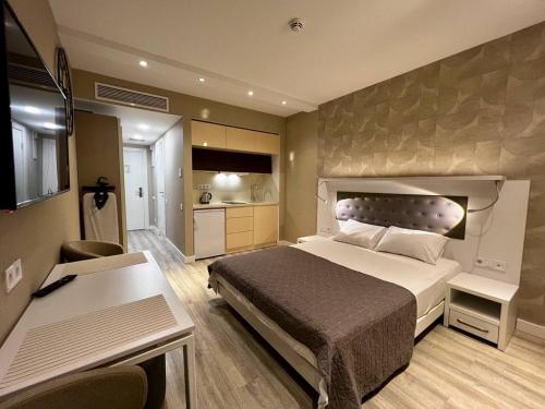 a bedroom with a large bed and a kitchen at Sunshine Apartments Batumi Lux in Batumi
