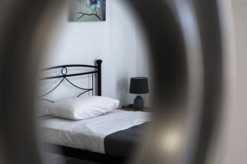 a bedroom with a bed with white sheets and a lamp at Blue Sea Apartment in Adelianos Kampos