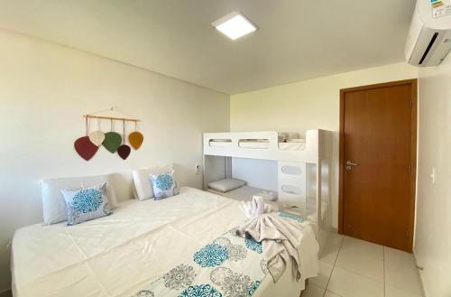 a bedroom with a bed with a bunk bed at Lindo Flat Praia dos Carneiros - Carneiros Beach Resort in Praia dos Carneiros