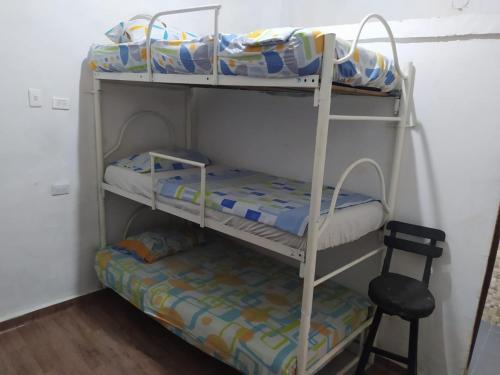 2 literas en una habitación con silla en Hostal #10-33 en Cartagena de Indias