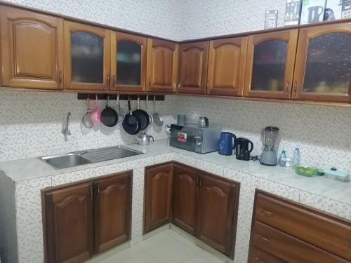 une cuisine avec des armoires en bois et un comptoir dans l'établissement AMDI Appartement, à Dakar