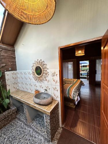 a room with a bench and a bed and a mirror at Sunny Rose Bungalows Gili Air - Adults only in Gili Air