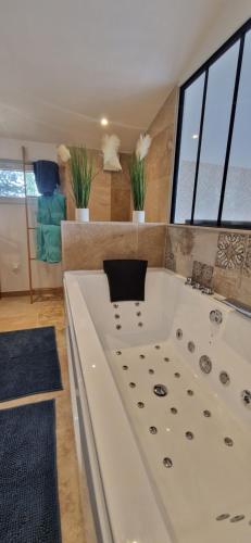 - une grande baignoire blanche dans une chambre avec fenêtres dans l'établissement Maison dans les vignes, aux Arcs-sur-Argens