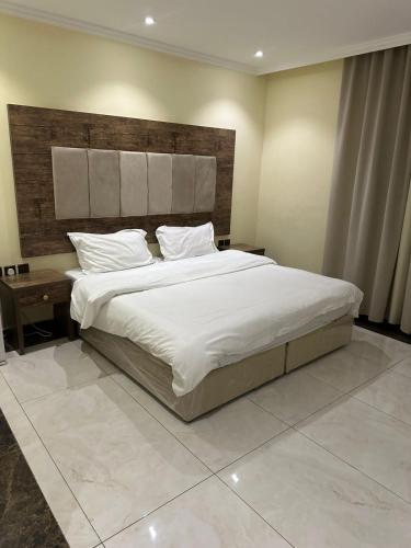 كيان حراء للشقق المخدومة- Kayan Hiraa Serviced Apartments في جدة: غرفة نوم بسرير كبير مع شراشف بيضاء