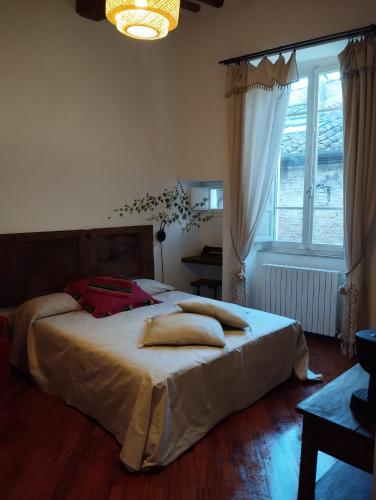 um quarto com uma cama grande com almofadas em Monolocale indipendente La Piazzetta - Centro storico em Perugia