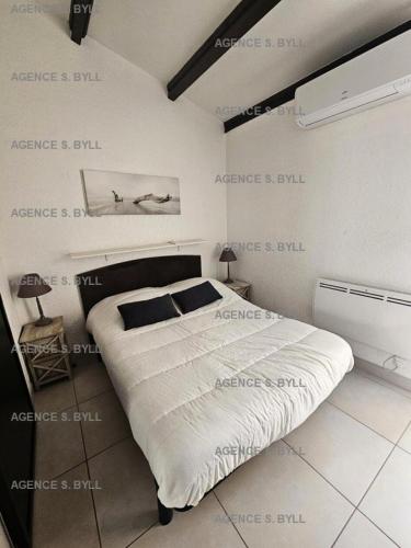 une chambre avec un grand lit avec une affiche sur le mur dans l'établissement Résidence Héliovillage - VILLA 4 couchages CAP d'AGDE MAE-2804, au Cap d'Agde