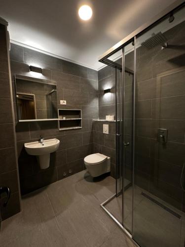 uma casa de banho com um WC, um lavatório e um chuveiro em Riva em Ulcinj